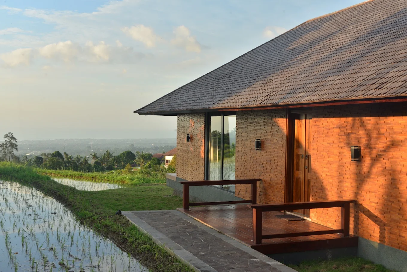 Villa exterior at golden hour overlooking rice fields
